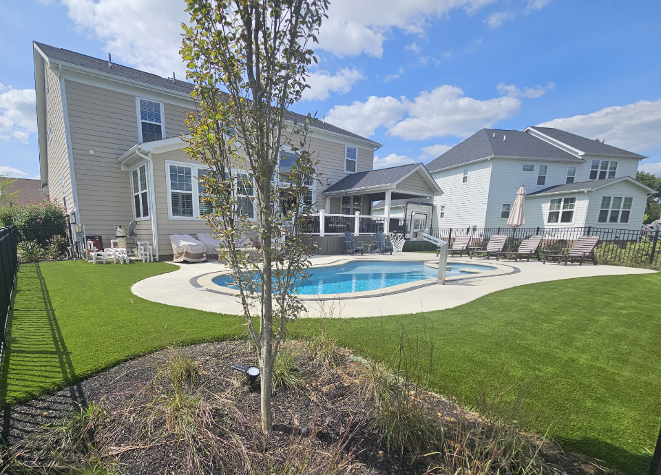 artificial grass lawn arounds a pool area in ohio backyard
